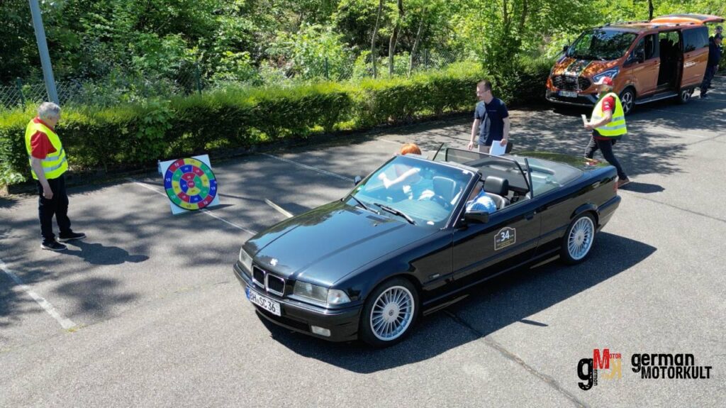 Schwarzes Cabrio-Oldtimer fährt bei der ADAC Youngtimer-Tour Südbaden 2026 mit Begleitern in Warnwesten auf Parkplatz