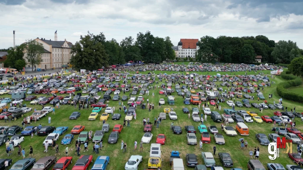 Hunderte Oldtimer und Youngtimer parken auf großer Wiese beim Maxlrainer Oldie Feeling in Bayern, Zuschauer zwischen den Fahrzeugen
